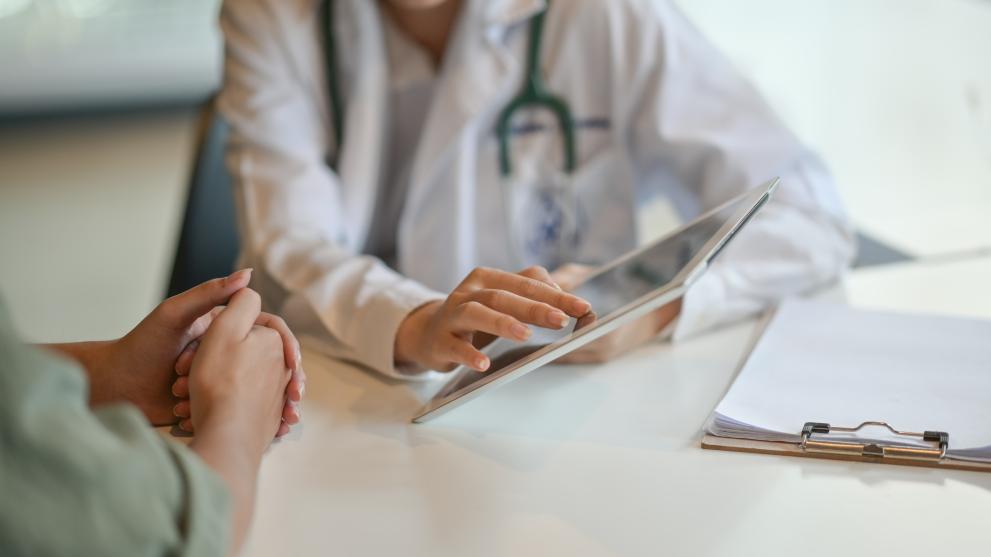 A female doctor showing data from a digital device
